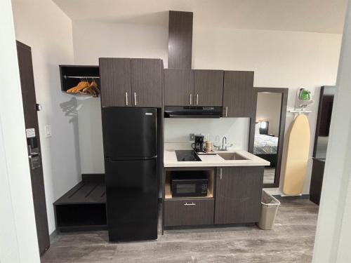 a kitchen with a black refrigerator and a sink at Studio 6 Giddings in Giddings