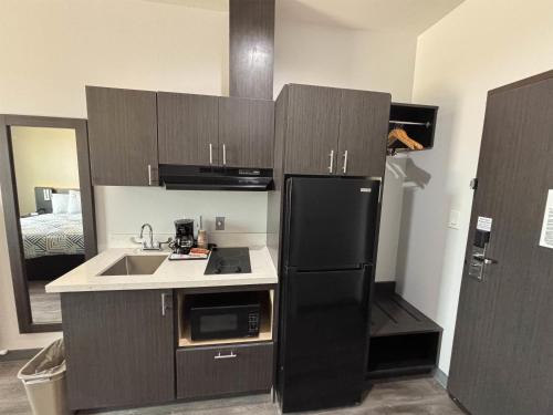 a kitchen with a black refrigerator and a sink at Studio 6 Giddings in Giddings