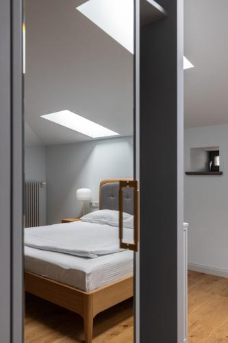 a bedroom with a bed and a ceiling at Roze Center Apartments in Liepāja