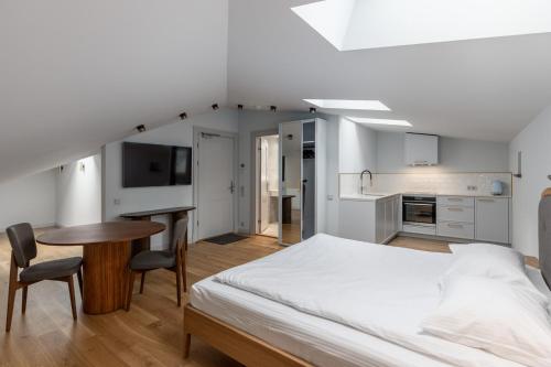 a bedroom with a bed and a table and a kitchen at Roze Center Apartments in Liepāja