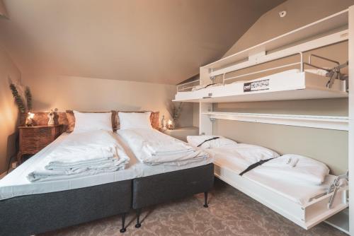 a bedroom with two bunk beds with white sheets at Villa Havblikk Tromsø in Tromsø