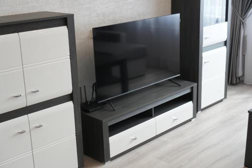 a black entertainment center with a flat screen tv at Kuncų apartments, self-check in, free parking, cozy in Klaipėda