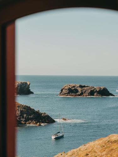 a sailboat in the water near a rocky island at Le Grand Large, Belle-Ile-En-Mer in Bangor