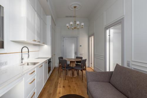 a kitchen and living room with a couch and a table at Roze Center Apartments in Liepāja