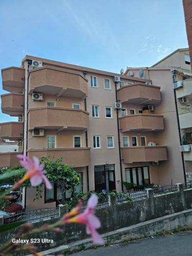 two pink birds flying in front of a building at Apartmani Alexandra in Budva