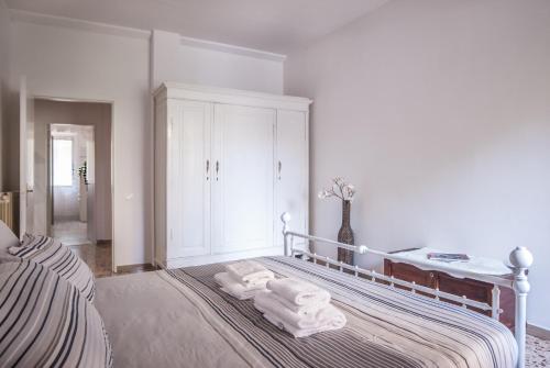 a white bedroom with a bed with towels on it at Scandicci Flat - 15 mins from Florence in Scandicci