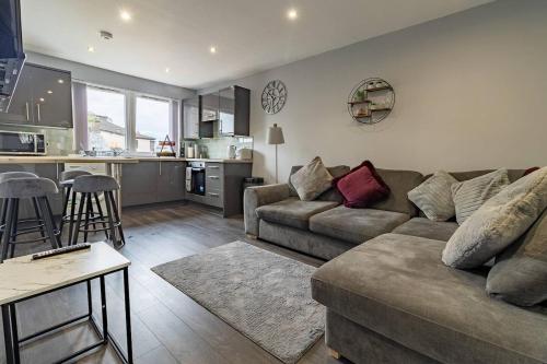 a living room with a couch and a kitchen at The Loft - 3 bedroom in Crieff in Crieff