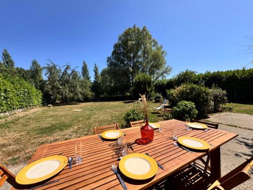 a wooden table with yellow plates on top of it at Le Grand Bricoin - Campagne - Parking - 12 pers in Thorigné-sur-Dué