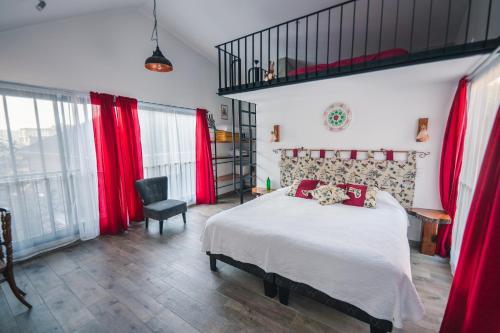 a bedroom with a large bed with red curtains at AYCA La Flora Hotel Boutique in Valparaíso
