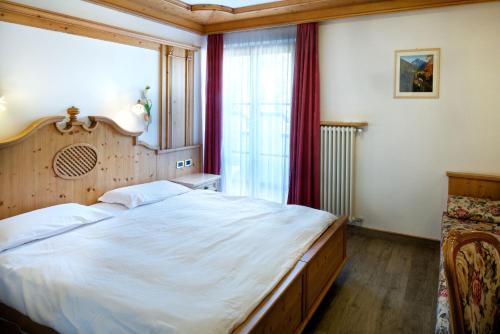 a bedroom with a large bed and a window at EL CIASEL in Canazei