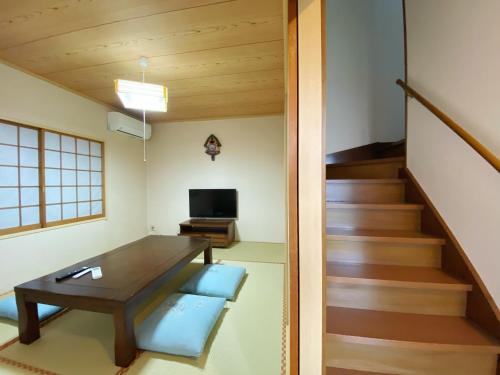 a living room with a table and a staircase at Vacation stay fujiyoshida in Fujiyoshida