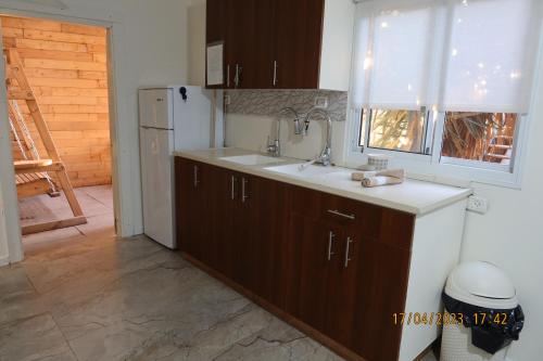a kitchen with a sink and a refrigerator at אחוזת ישוב הדעת in Safed