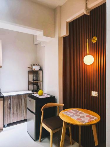 a kitchen with a table and a small table and chair at Kuya Os Staycation at Royal Oceancrest Condominium Panglao in Dauis
