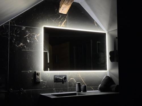 a bathroom with a mirror and a sink at BlackRoom - Balnéo - Ciel étoilé in Belfort