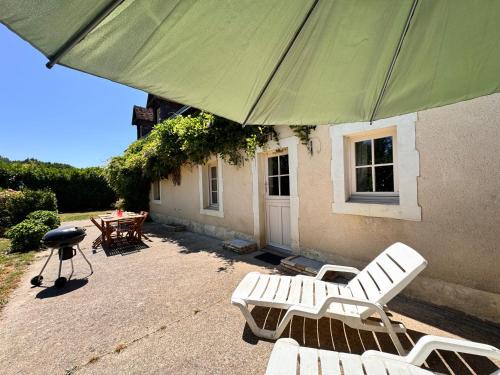 a patio with two chairs and a grill and a green umbrella at Le Grand Bricoin - Campagne - Parking - 12 pers in Thorigné-sur-Dué