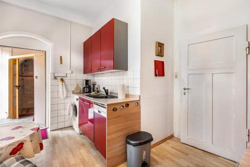 a kitchen with red cabinets and a white wall at Ferienwohnung mit Pool - Moritzburg in Moritzburg