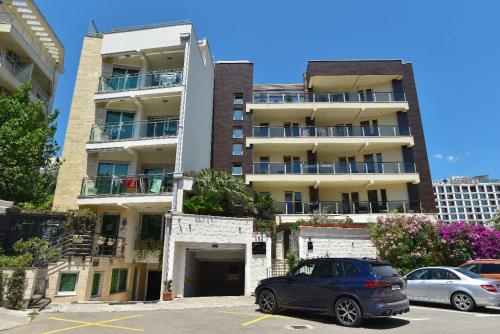 Un coche aparcado en un estacionamiento frente a un edificio. en Omega 4 Apartment, en Budva