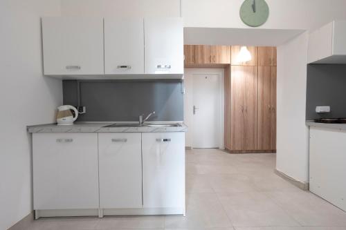 Una cocina con gabinetes blancos y un fregadero. en Central flat at plac Konstytucji, en Varsovia