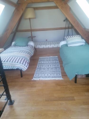 une chambre mansardée avec deux chaises bleues et un plancher en bois dans l'établissement La belle demeure de Margot, à Monbazillac