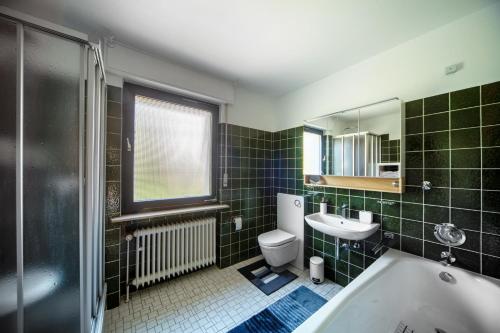 a bathroom with a tub and a toilet and a sink at cruwzo Home Wuppertal- Komfort trifft Stil in Wuppertal