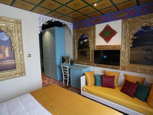 a room with a bed and a couch and a table at Gardaland Adventure Hotel in Castelnuovo del Garda