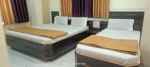 two twin beds in a room at Hotel Sai viraj palace in Shirdi
