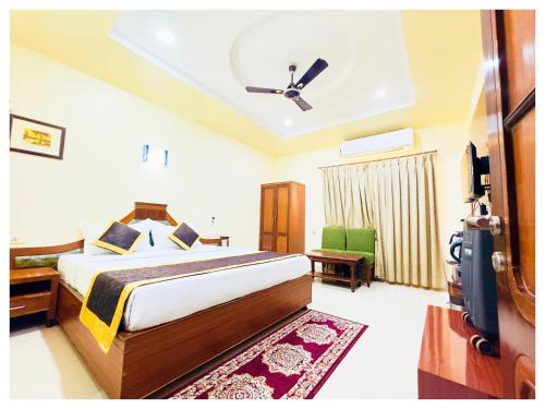 a bedroom with a bed and a ceiling fan at Power Onn Grand Cuttack Residency in Cuttack