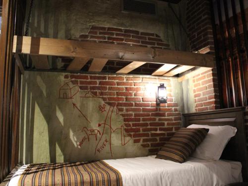 a bed in a room with a brick wall at Gardaland Adventure Hotel in Castelnuovo del Garda