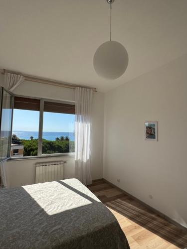 a bedroom with a bed and a large window at Casa al Mare Suite - Fronte spiaggia - Parcheggio in Cogoleto