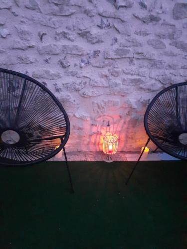 two chairs sitting next to a fire in a room at Gîte pres de Giverny in Gasny