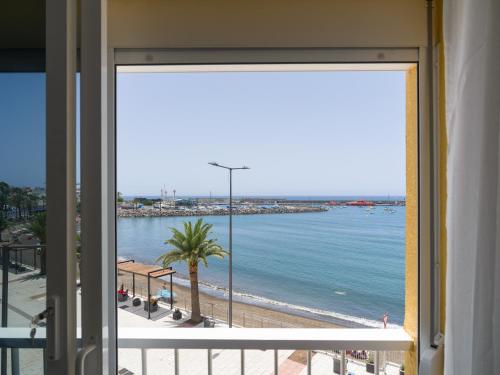 a view of the ocean from a room with a window at Marañuelas Beach Suites Arguineguin in Arguineguín
