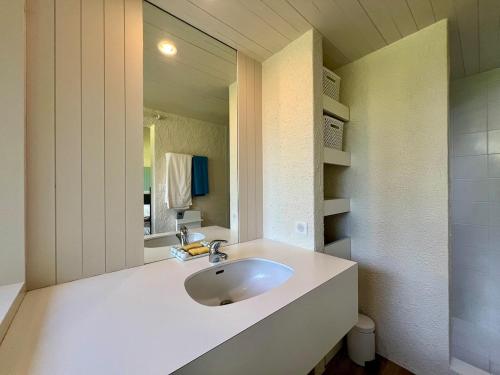 ein weißes Badezimmer mit Waschbecken und Spiegel in der Unterkunft Magnifique Villa en Dordogne Piscine chauffée in Saint-Aulaye