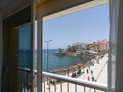 a balcony with a view of a beach and the ocean at Marañuelas Beach Suites Arguineguin in Arguineguín