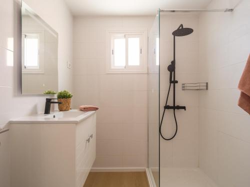 a white bathroom with a shower and a sink at Marañuelas Beach Suites Arguineguin in Arguineguín