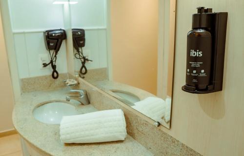 a bathroom counter with a sink and a mirror at Ibis Styles Macaé in Macaé
