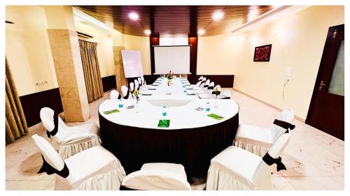 a large meeting room with a long table with white chairs at Power Onn Grand Cuttack Residency in Cuttack