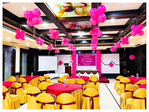 a banquet hall with red and yellow tables and balloons at Power Onn Grand Cuttack Residency in Cuttack