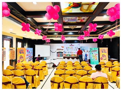 a room filled with yellow chairs with pink balloons at Power Onn Grand Cuttack Residency in Cuttack