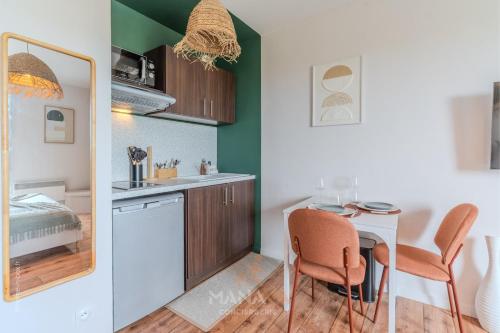 a small kitchen with a table and chairs in a room at Le Tahiti, 2 pers, 10 min Disneyland Paris in Marne-la-Vallée