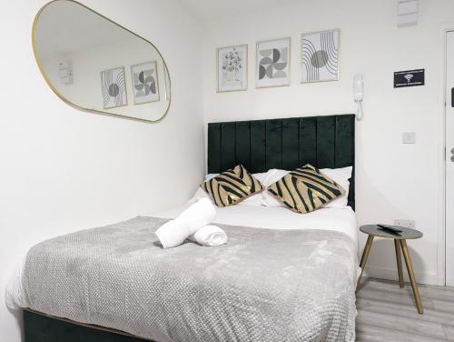 a bedroom with a bed with a mirror on the wall at Private & Relaxed Apartments 1-5 in Cardiff