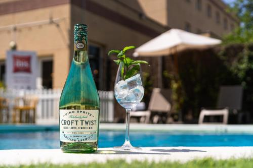 a bottle of wine and a glass next to a pool at Ibis Jerez De La Frontera Cadiz in Jerez de la Frontera