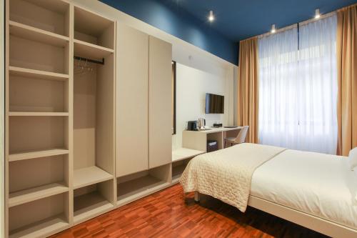 a bedroom with a bed and a room with shelves at cvm 19 in Milan