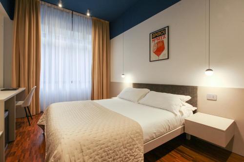 a bedroom with a bed and a desk and a window at cvm 19 in Milan