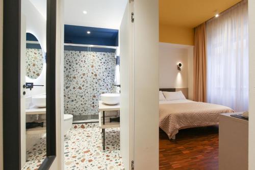 a bedroom with a bed and a bathroom with a sink at cvm 19 in Milan