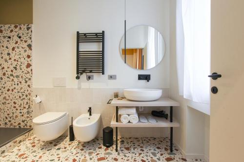 a bathroom with a toilet and a sink and a mirror at cvm 19 in Milan