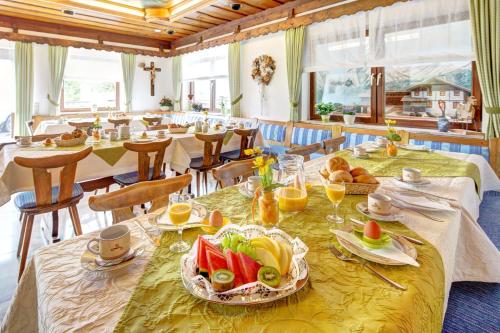 una sala da pranzo con tavolo e cibo di Steigmühle Pension Garni a Füssen