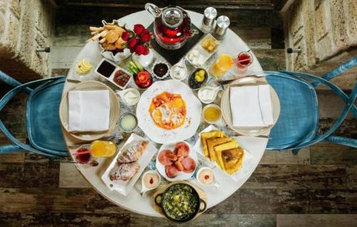 ein Tisch mit Frühstücksspeisen und Getränken darauf in der Unterkunft Sazeli Old Baku Hotel in Baku