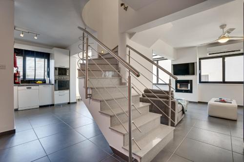 a spiral staircase in a living room in a house at Makenzy Star 2bd Duplex 300m From Beach in Aglantzia