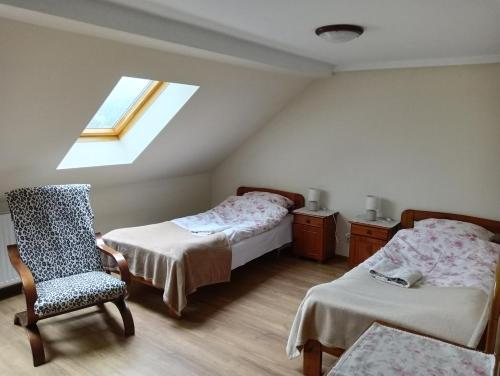 una camera da letto con due letti, una sedia e una finestra di U Asi w Kotlinie Kłodzkiej - Widoki, Bania i Wiejskie Smaki a Bozkow