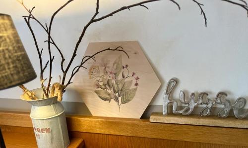 a table with a picture and a vase on a shelf at B&B Apart Hotel Goldener Hahn - Hygge Pool & Sauna in Baiersbronn